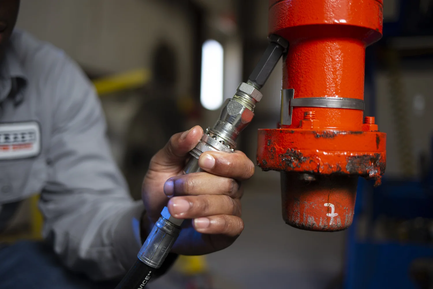 Hand and torch working a bright industrial fitting at close range