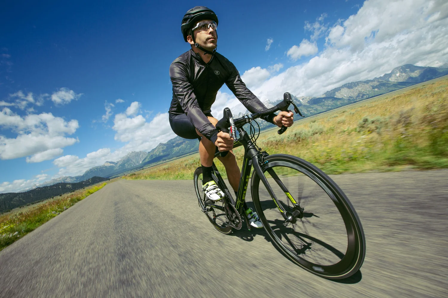 Road cyclist cornering at speed in open terrain