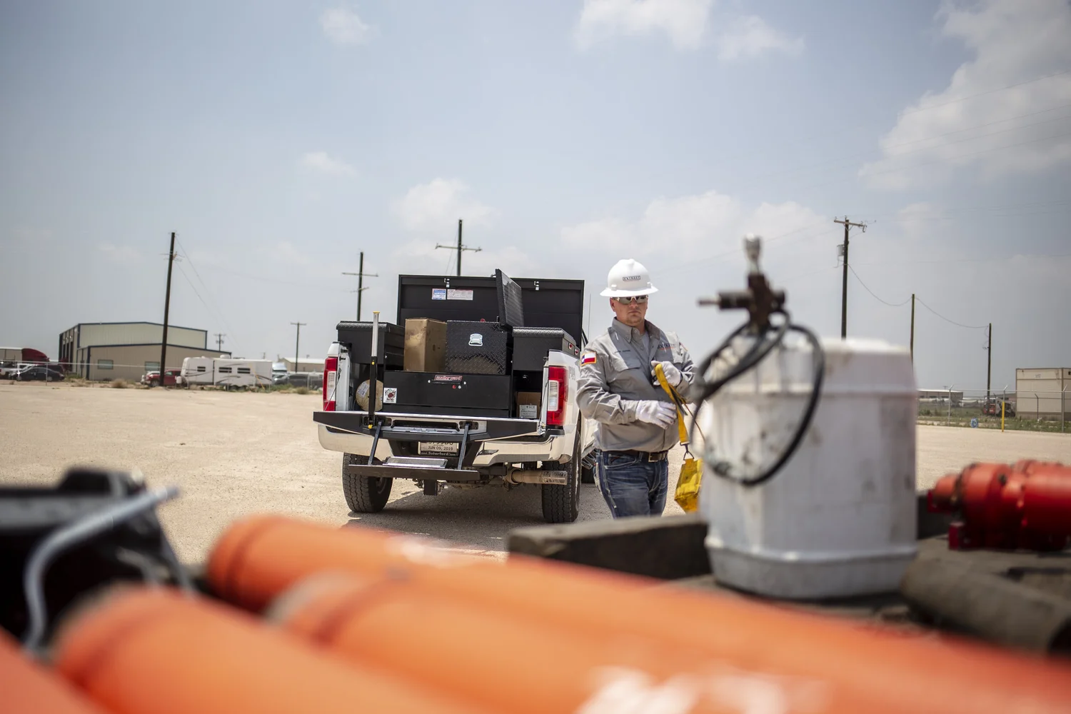 Field worker framed across active equipment and open industrial space