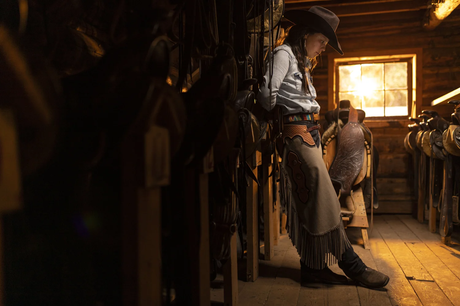 Quiet Western portrait beside saddle and tack