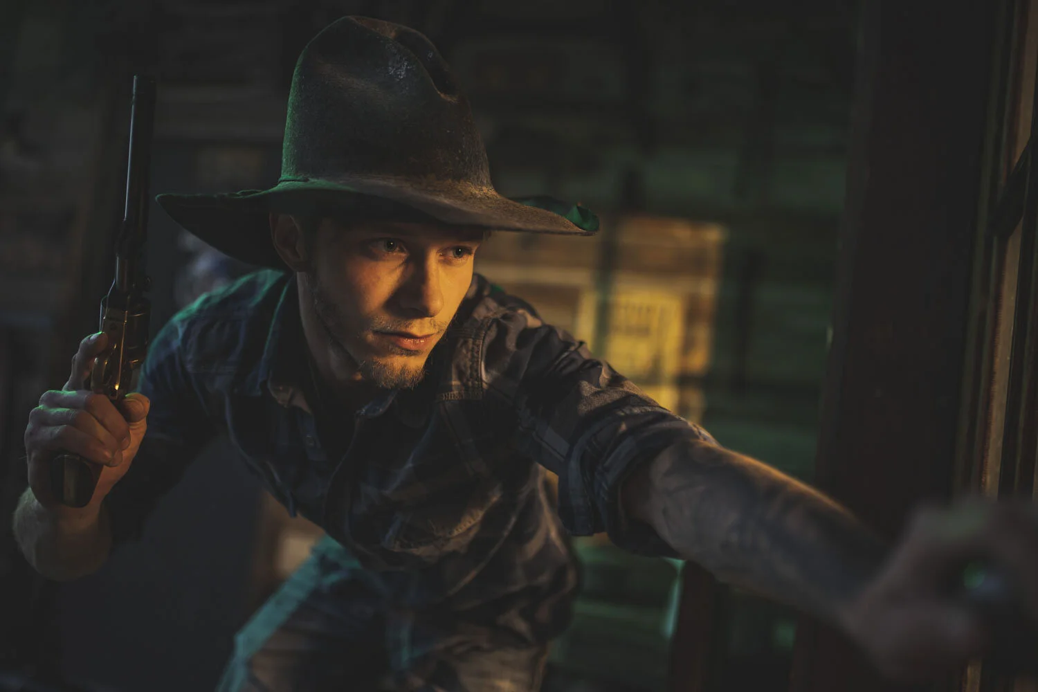 Cowboy portrait framed by a dark stable interior