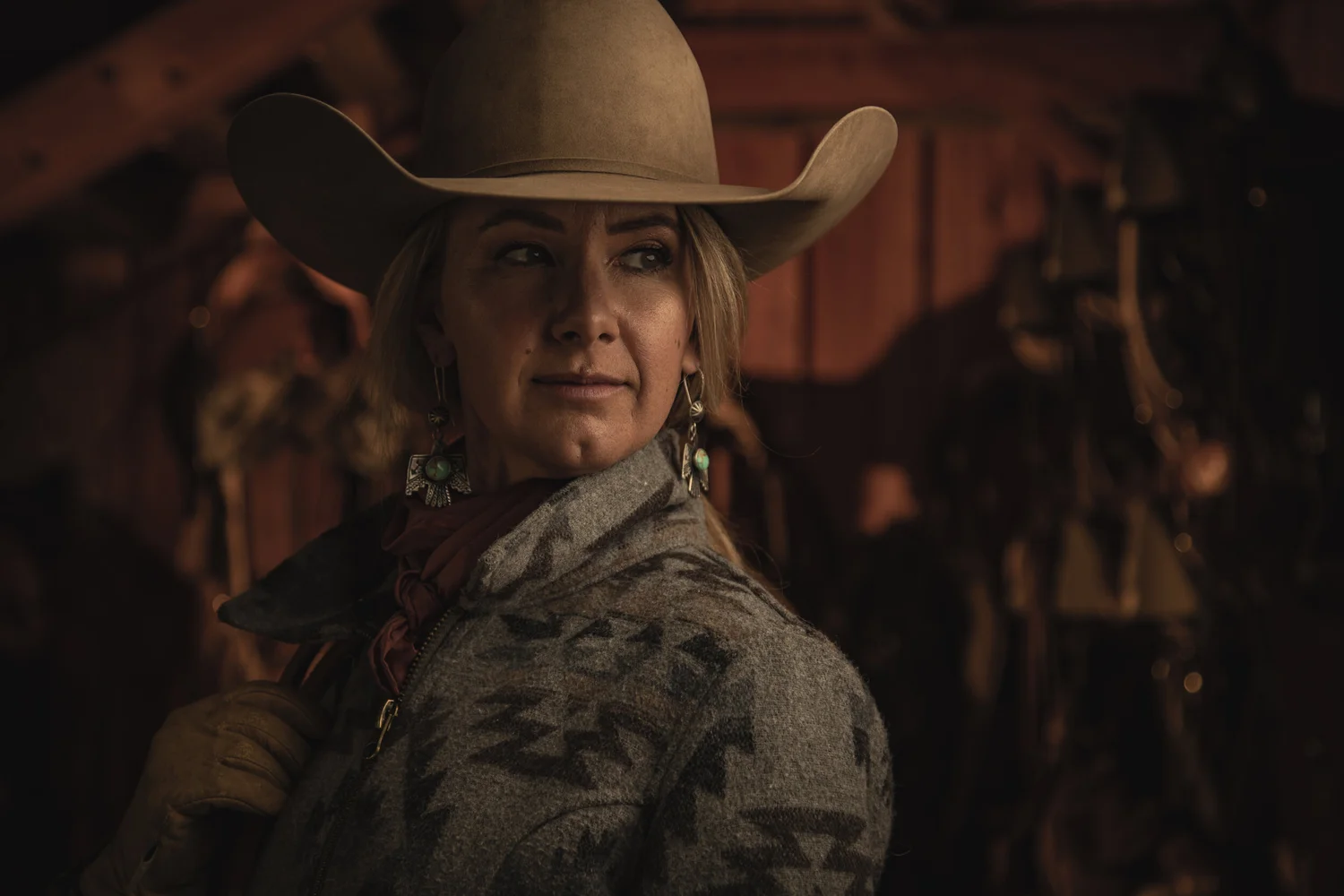 Western portrait held in warm working-barn light