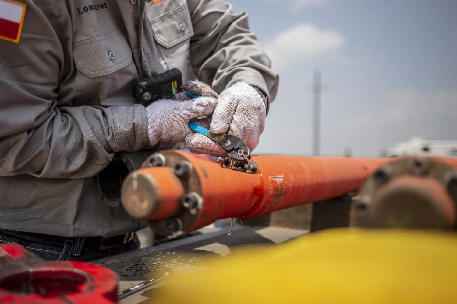 Close process detail of gloved hands working on industrial equipment