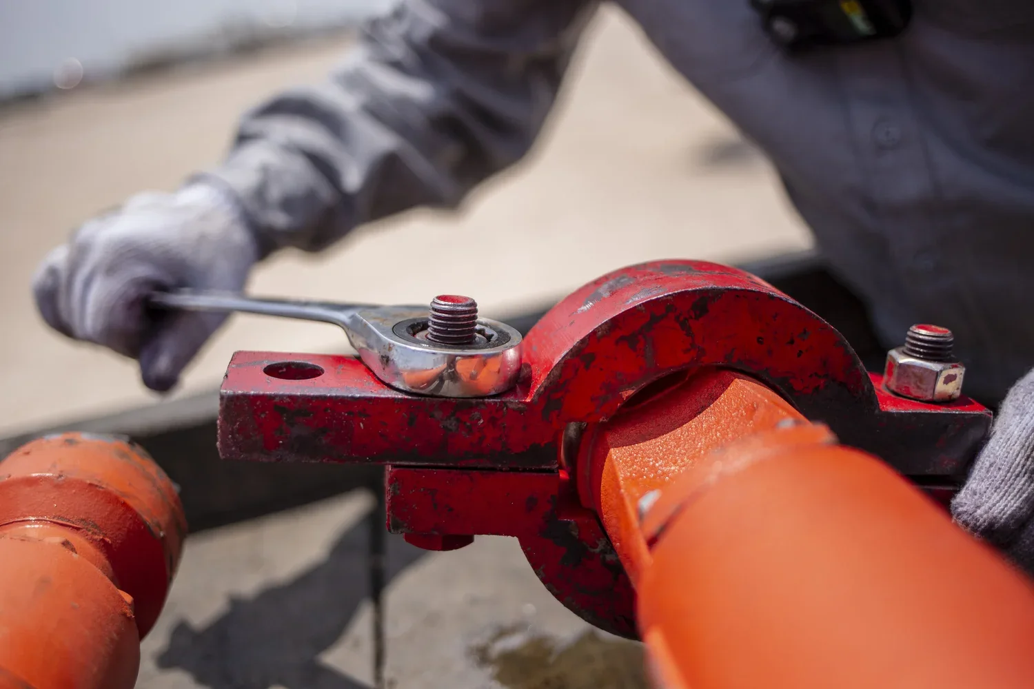 Close industrial tool detail against orange field pipe