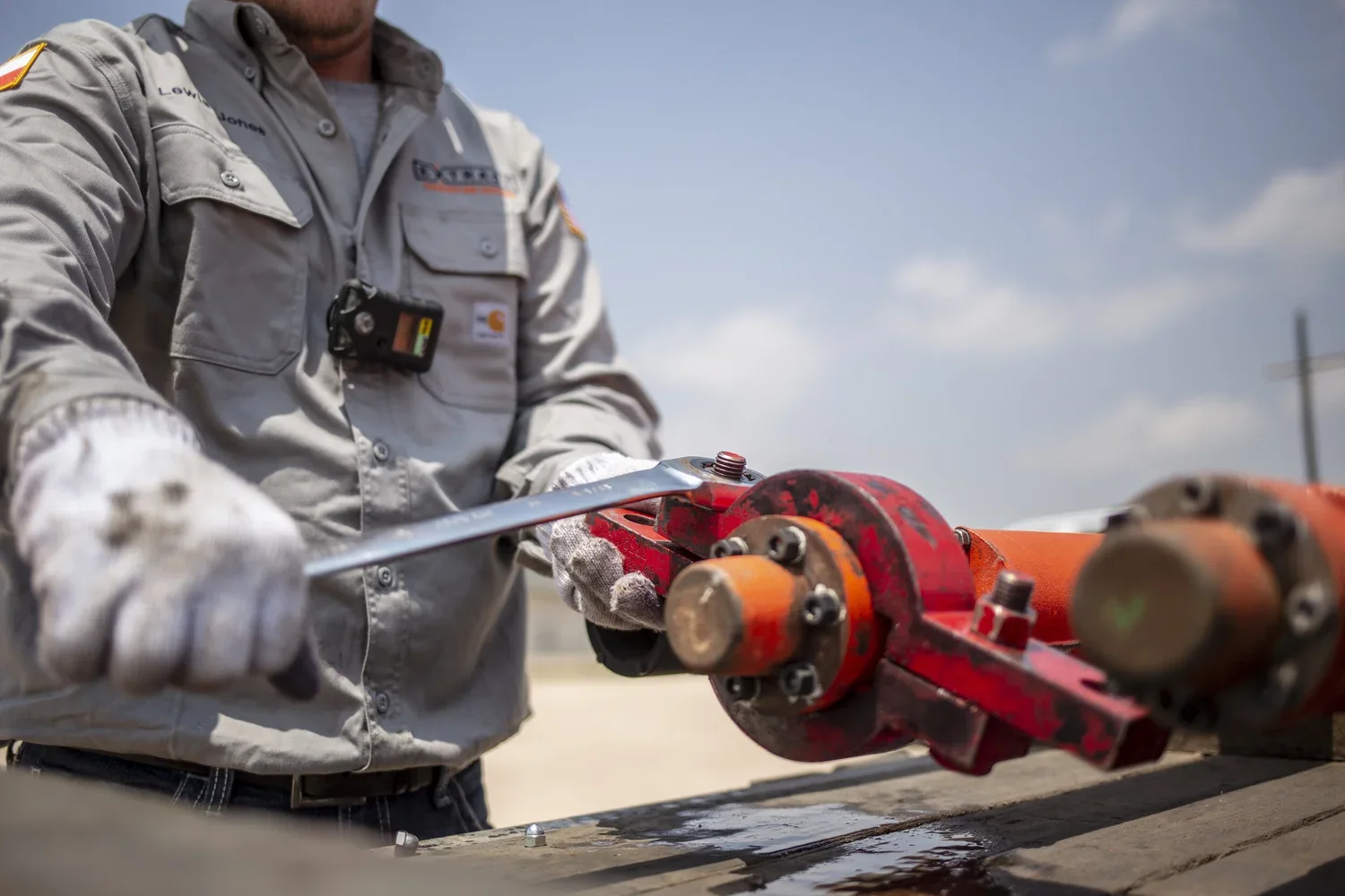 Technician using a red industrial tool at close range