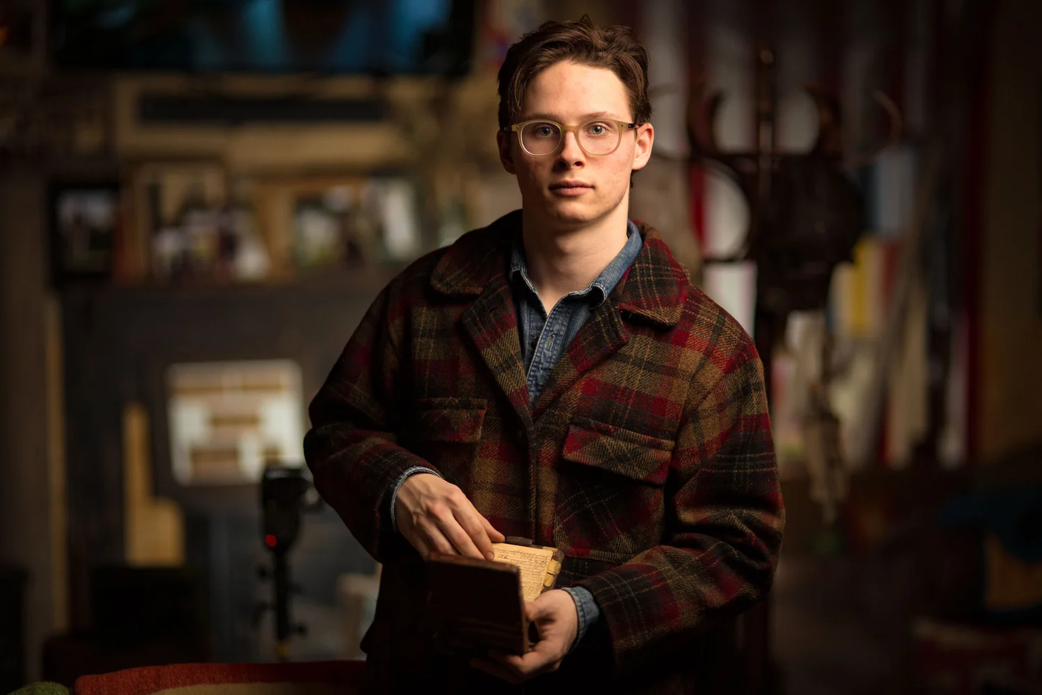 Editorial male portrait holding a Rolodex with a direct, offbeat expression