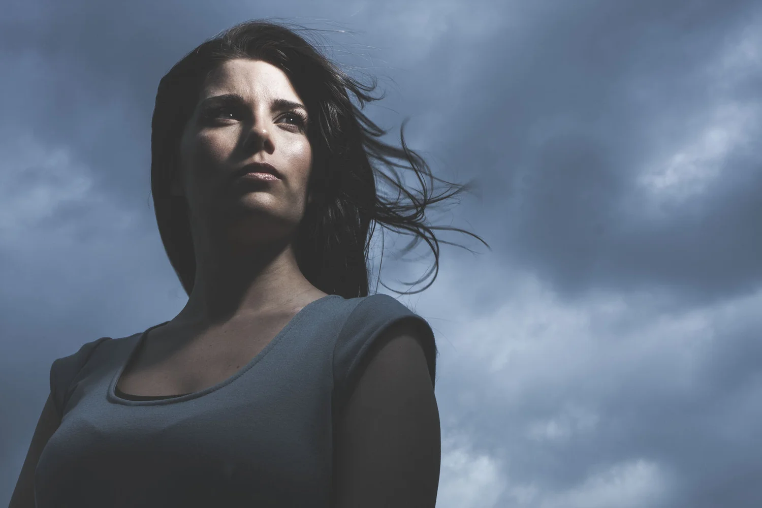 Cinematic advertising portrait against a dramatic sky