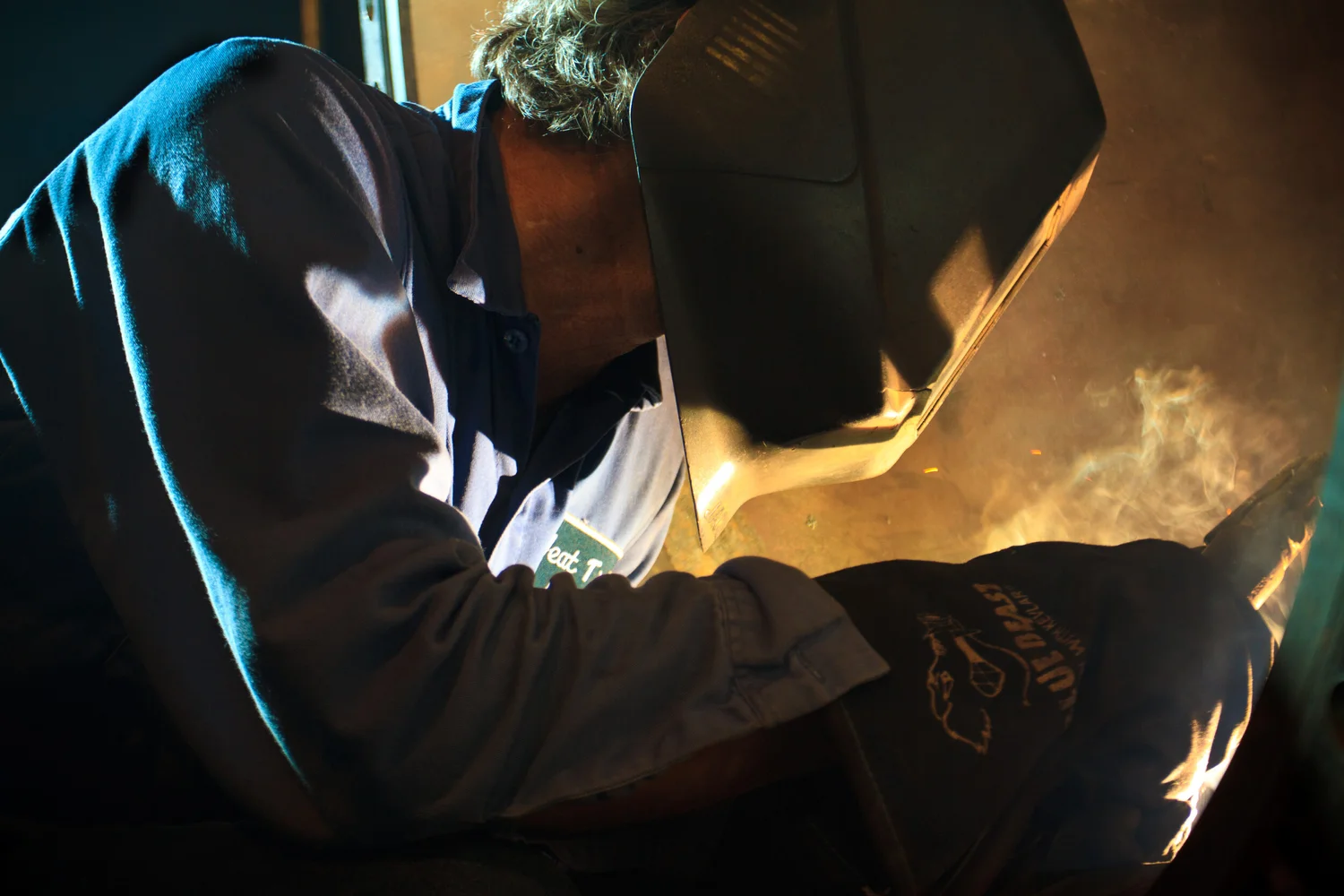 Welder photographed in controlled industrial light
