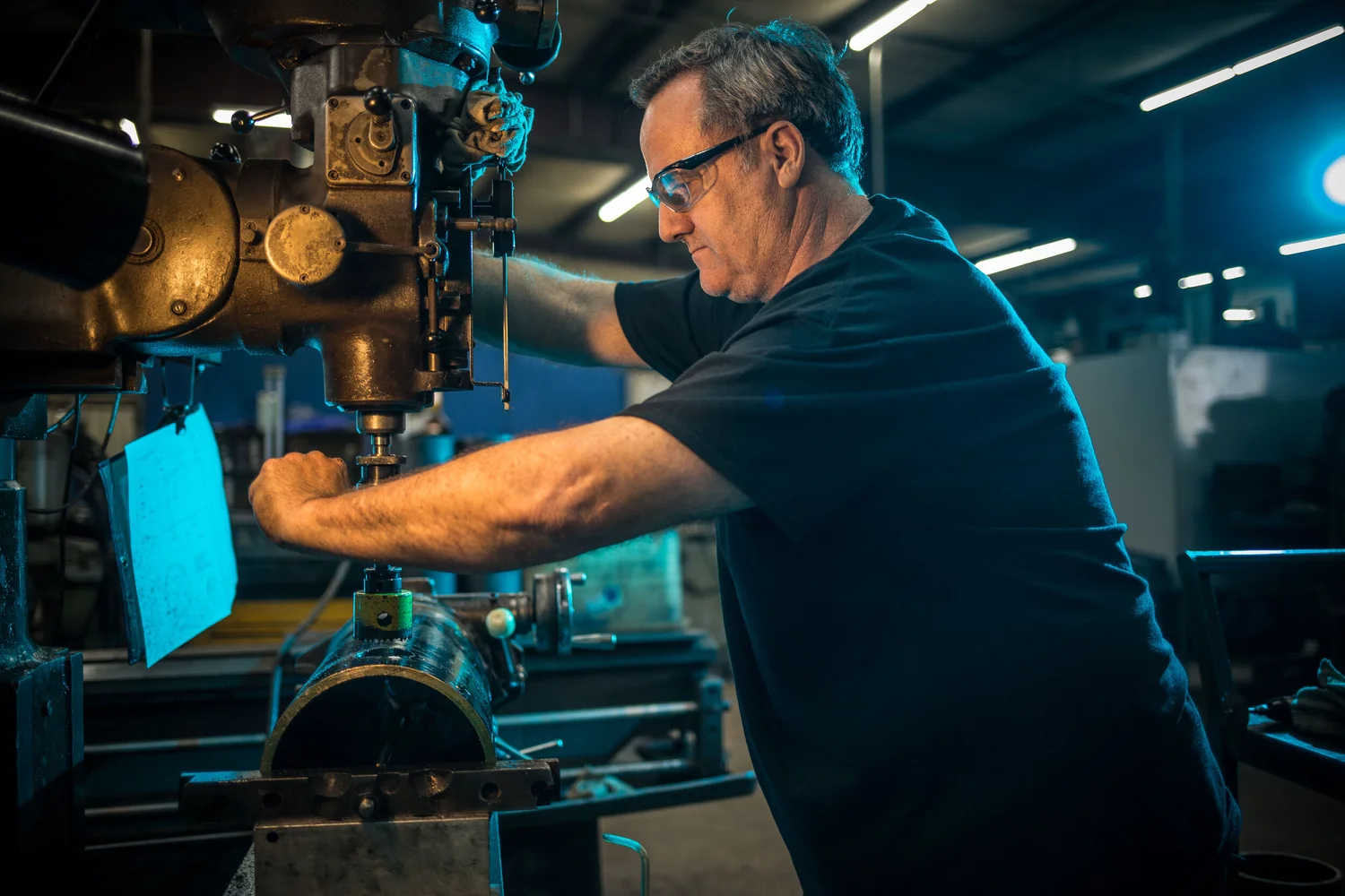 Machinist operating equipment under controlled blue working light