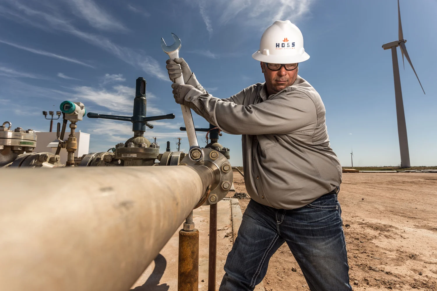 Field worker using a large wrench on an active site